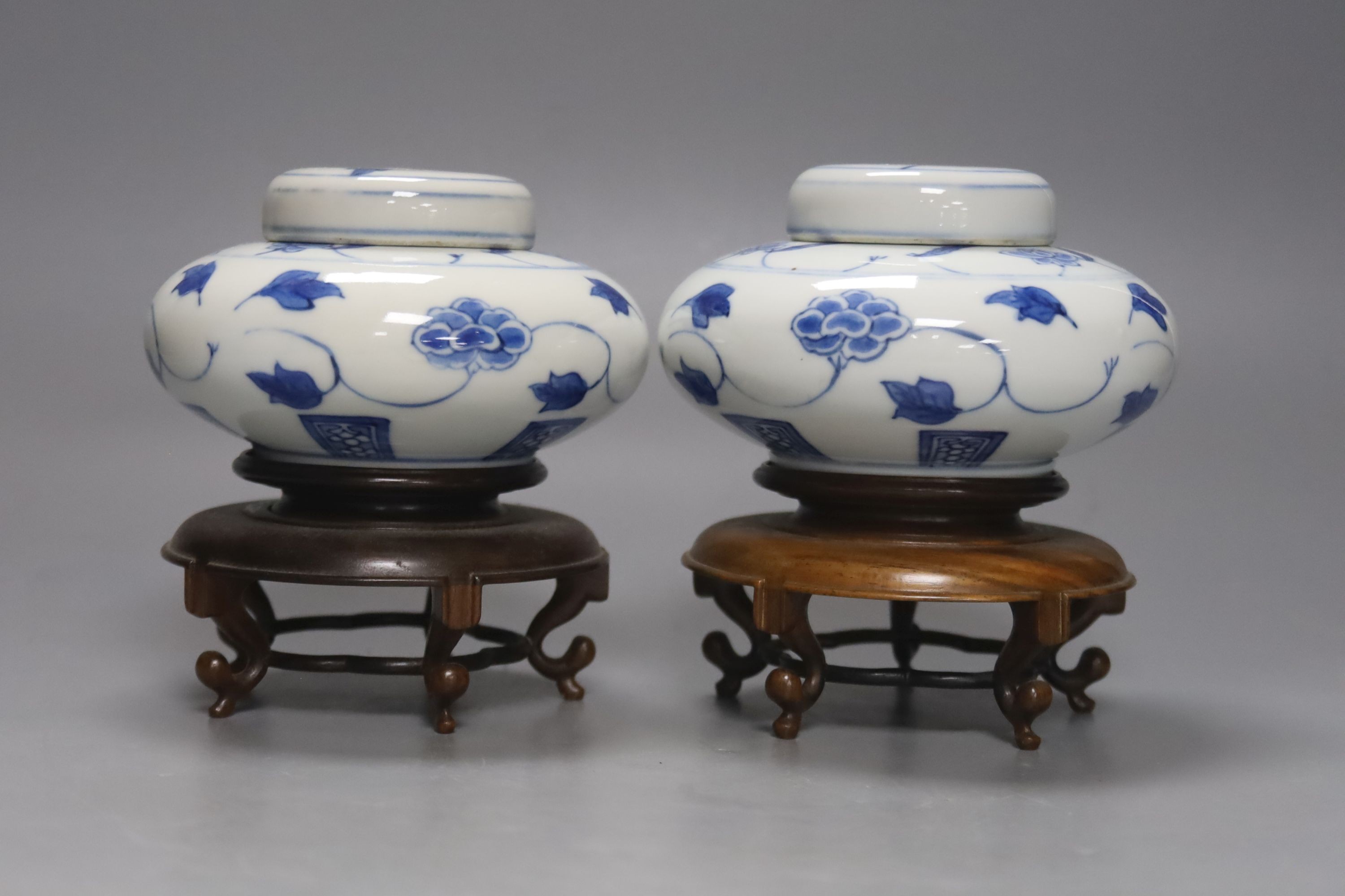 A pair of Chinese blue and white jars and covers, 6.5cm, on wood stands, a Chinese blue and white bowl and two small enamelled wine cups